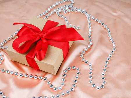 gift box with red bow, on a Nude satin background, wedding and Christmas concept.の写真素材