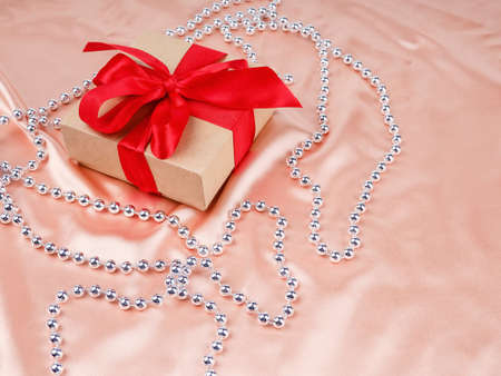 gift box with red bow, on a Nude satin background, wedding and Christmas concept.の写真素材
