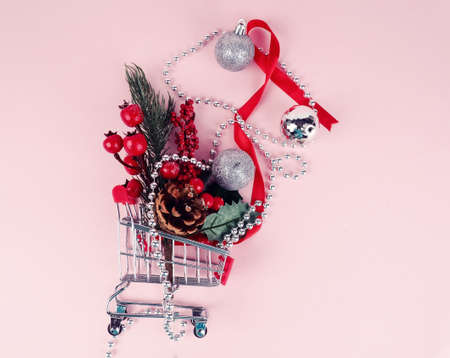 Shopping cart with gift or present and fir tree on snowy effect background. Christmas and New year sale concept. Vintage greeting cardの写真素材