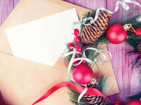 Christmas envelope with greetings design on red wooden background with Christmas wreath.の写真素材