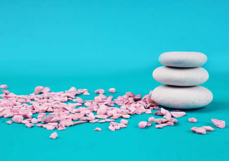 Zen stones on a blue background, next to pink stones, the concept of calm.の写真素材