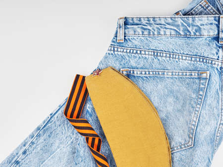 Modern jeans and symbols of victory in the Second World War. St. Georges ribbon, military cap, cartridges and letters from the front. The concept of victory on May 9 for a postcard backgroundの写真素材
