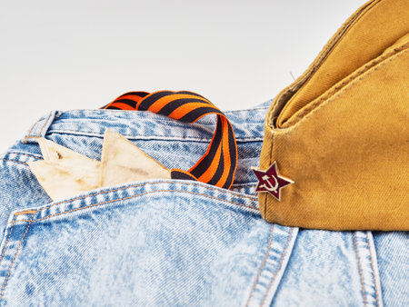 Modern jeans and symbols of victory in the Second World War. St. Georges ribbon, military cap, cartridges and letters from the front. The concept of victory on May 9 for a postcard backgroundの写真素材