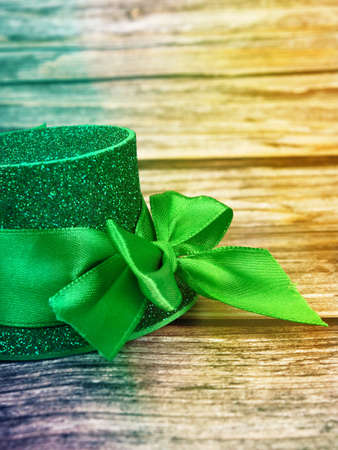 Green hat with golden coins and shamrock on wooden table, st patricks day conceptの写真素材
