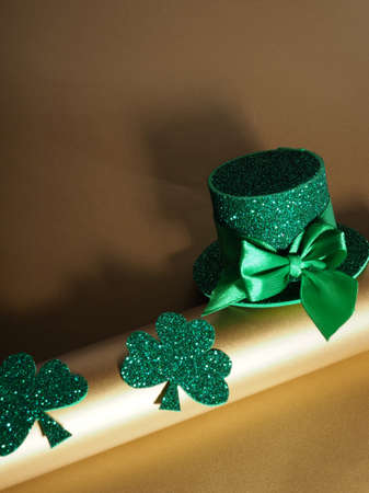 Green hat with golden coins and shamrock on gold table, st patricks day conceptの写真素材