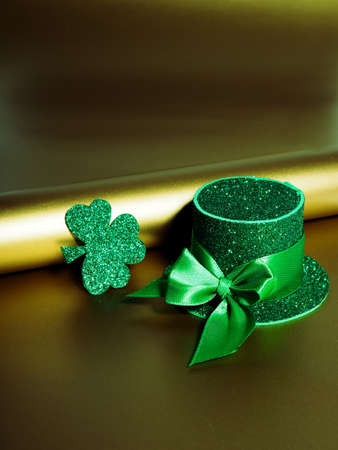 Green hat with golden coins and shamrock on gold table, st patricks day conceptの写真素材