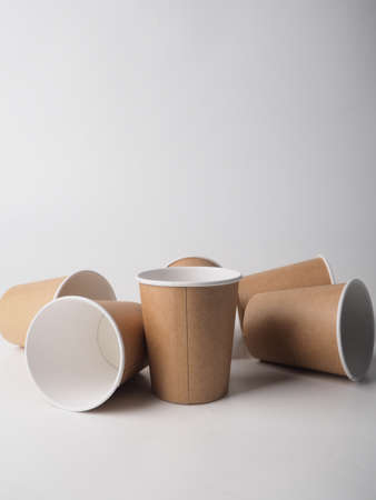 Several paper disposable brown cups are randomly placed on a white background.の写真素材