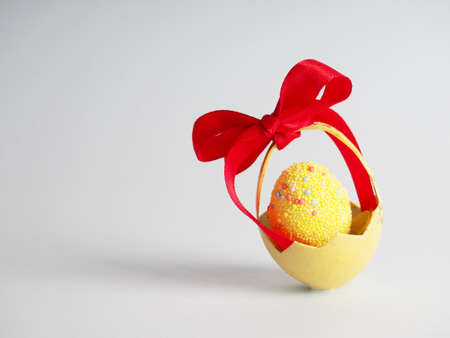 One yellow egg in a shell, with a bow, Easter concept.の写真素材