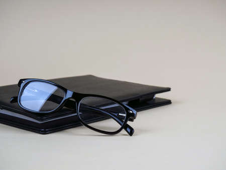 Black business notebook, glasses on them. Business concept, place for text.の写真素材