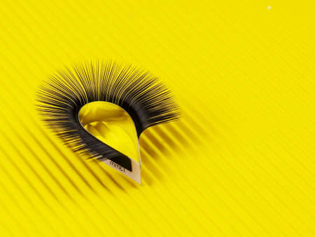 One strip of eyelashes for arc extension on a yellow background.の写真素材