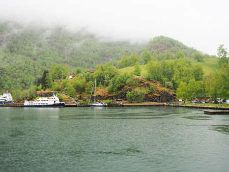 Natural landscape, Scandinavian fjords and river, Norwegian houses on the shore.の写真素材