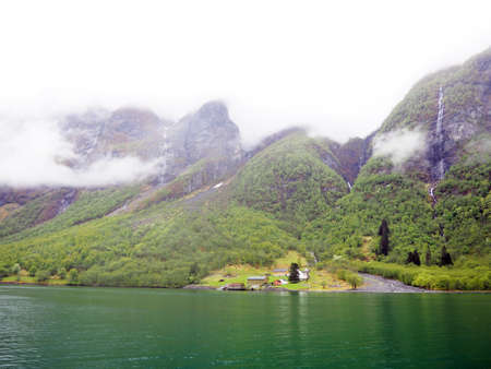 Natural landscape, Scandinavian fjords and river, Norwegian houses on the shore.の写真素材