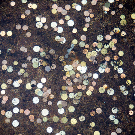 A lot of coins from different countries at the bottom of the fountain, for luck.の写真素材