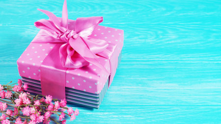 One gift box with a pink bow on a wooden background, copy of the text space.の写真素材