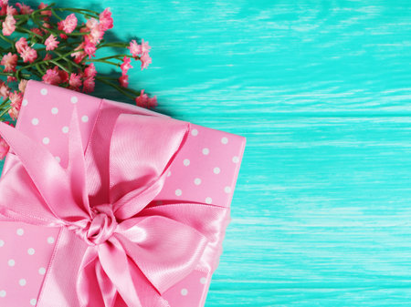 One gift box with a pink bow on a wooden background, copy of the text space.の写真素材