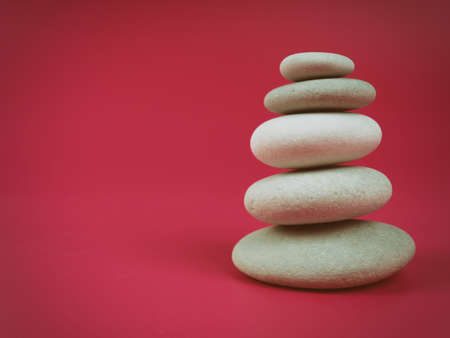 A stack of white zen stones on a pink background, minimalism.の写真素材