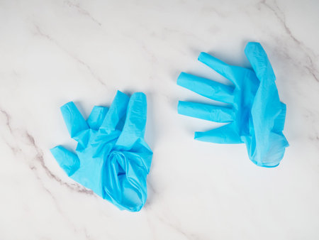 Used medical gloves on a marble background.