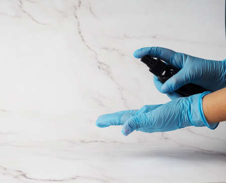 hands in medical gloves hold antiseptic to prevent a pandemic. desinfection hand sanitizer applying alcohol.の写真素材