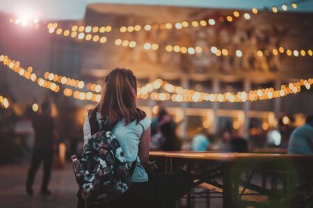 Tirana, Albania. September 17, 2017: Young girl with backpack enjoying illuminated city center. Evening in Tiranaâs main Skanderbeg square decorated with lights for the festival.のeditorial素材