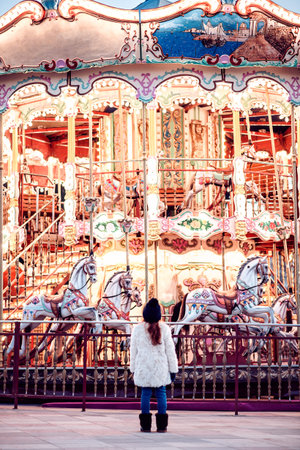 little girl looking up at the large vintage carouselの写真素材