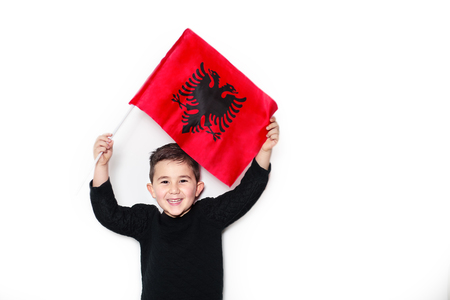 Little boy happy face raising Albanian National Flag on white backgroundの写真素材