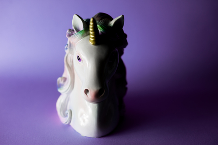 Closeup unicorn figure on ultraviolet background half light half shadowの写真素材