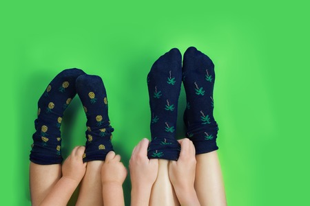 Legs with cute blue socks on green background.の写真素材