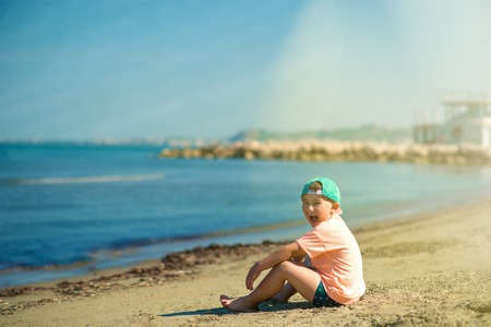 Back view of cute boy on the seaside. Summer vacation.の写真素材
