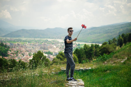 BERAT, ALBANIA - June 2018: Tourist making selfie in Berat castle, ottoman architecture in Albania,...