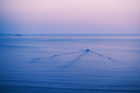 Aerial view to beach of Adriatic sea in Albania, small boat sails away from Port of Durres in horizonの写真素材