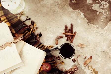 Autumn composition. Cup of coffee, blanket, autumn leaves, cinnamon sticks on beige background. Flat lay, top view.の写真素材