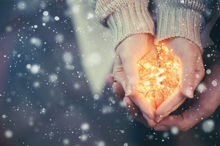 Close view of a couple holding warm Christmas lightsの写真素材