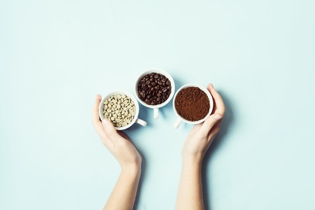Different types of coffee - ground, grain and unroasted on blue pastel backgroundの写真素材