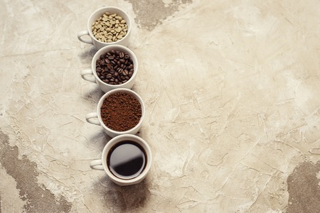 four types of coffee unroasted, bean, ground and one in cupの写真素材