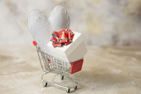 Valentines Day shopping concept. White heart and gift with red ribbonの写真素材