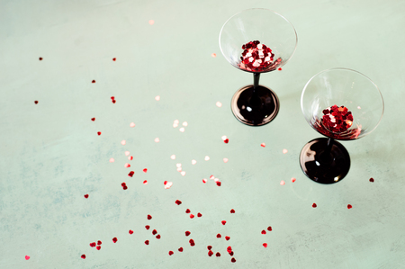 Two glasses of wine with small heart shaped confetti Valentines Day concept.の写真素材
