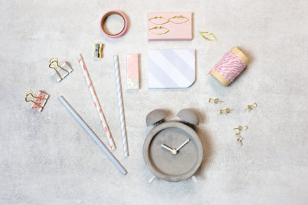 Over head view of flat lay pink and gold glamorous work space template grey background