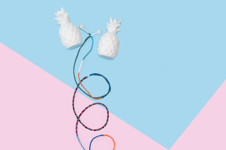 Colorful hippy earbud headphones on pastel blue background with copy spaceの写真素材