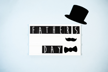 Father's day conceptual flat lay. Funny moustache, hat and text box top view on blue backgroundの写真素材