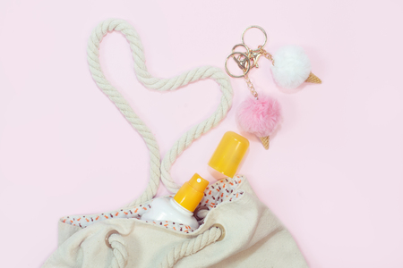 beach bag with beach top view with sunscreen on pink backgroundの写真素材