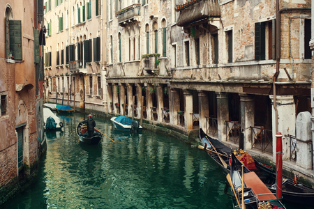 Classical picture of the venetian canals with gondola across the canal.の写真素材