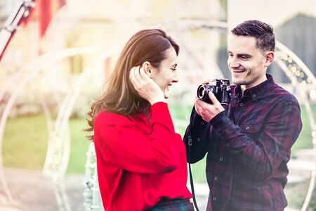 Happy couple taking photos of each other outdoorsの写真素材