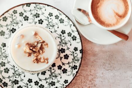 Albanian yogurt dessert with honey and walnuts nuts over white plateの写真素材