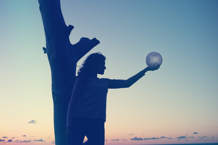 The girl holds the moon in her hands. sunset on the sea. Dreams come true.