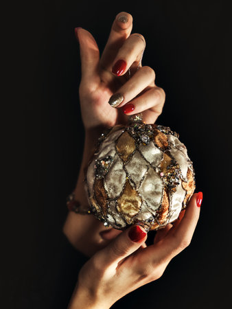 Close up woman hands with manicure holding Christmas baubleの写真素材