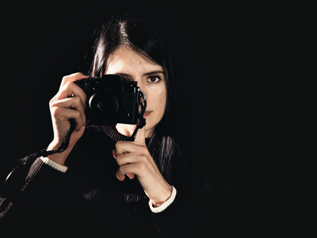 woman photographer close up camera black background