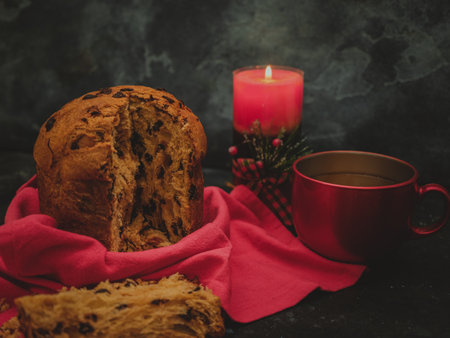 pannetona with tea and a candle in the far right on a black concrete backgroundの写真素材