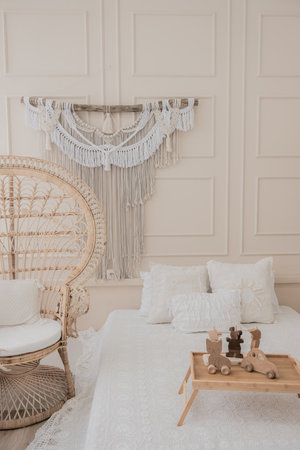 Boho style white bedroom with wooden toys and macrame decoration. High quality photoの写真素材