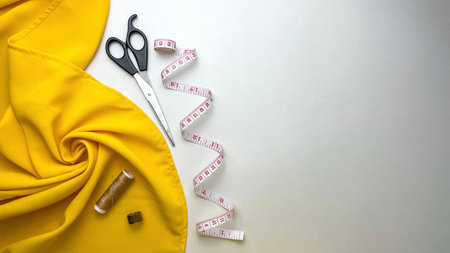 Yellow fabric and necessary sewing tools for creating clothes and repairing items.の写真素材