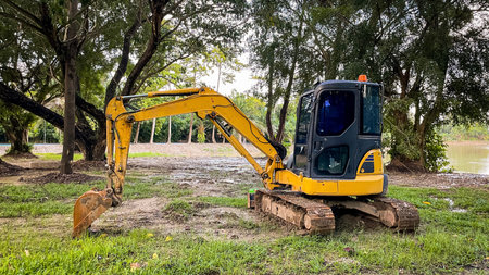 A compact mini excavator parked in a green area. This modern construction equipment is ideal for...